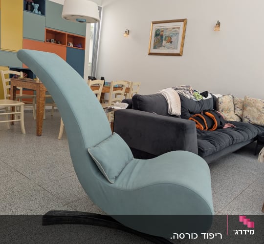 כורסה מעוצבת בחדר מגורים עם רהיטים נוספים